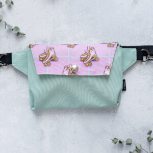 Produktfoto von der Bauchtasche ''pastell skater''. Die Bauchtasche ist in der Hauptfarbe pastellmint. Vorne mit einem Stoff der hellviolett ist und Rollerschuhe drauf zu sehen sind.